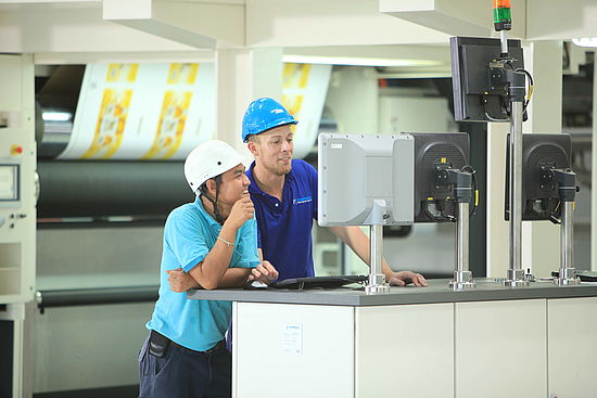 CONPRINTA supervisor in discussion with an operator at the main paneel.